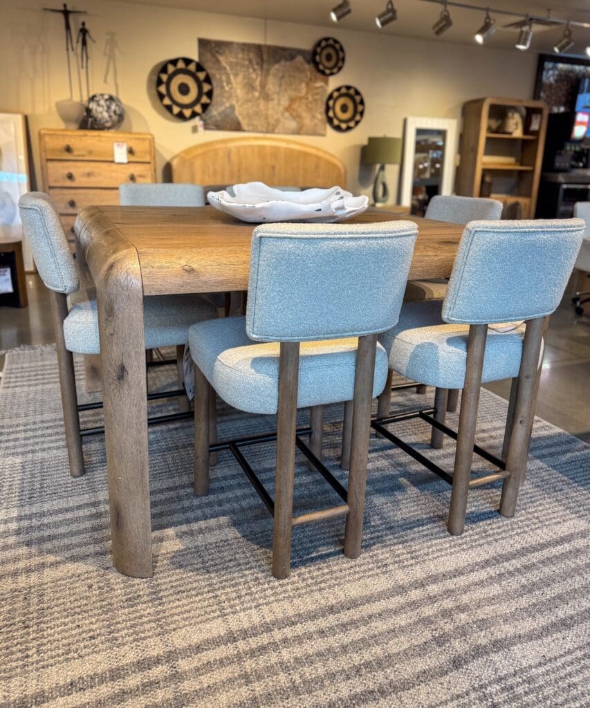 An image of a modern style curved edge counter height dining set with upholstered open back seating.