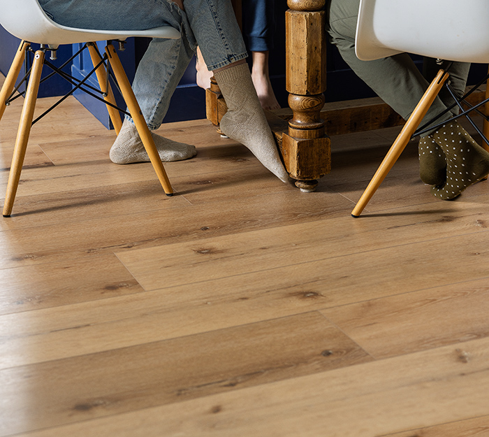 Lifestyle image of hardwood flooring with people seated on chairs.